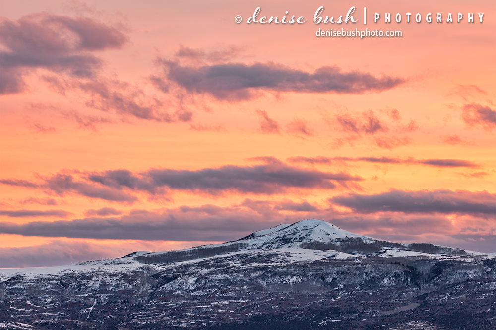 A small mountain beside the grand San Juans of Colorado is crowned with a beautiful sunet sky.