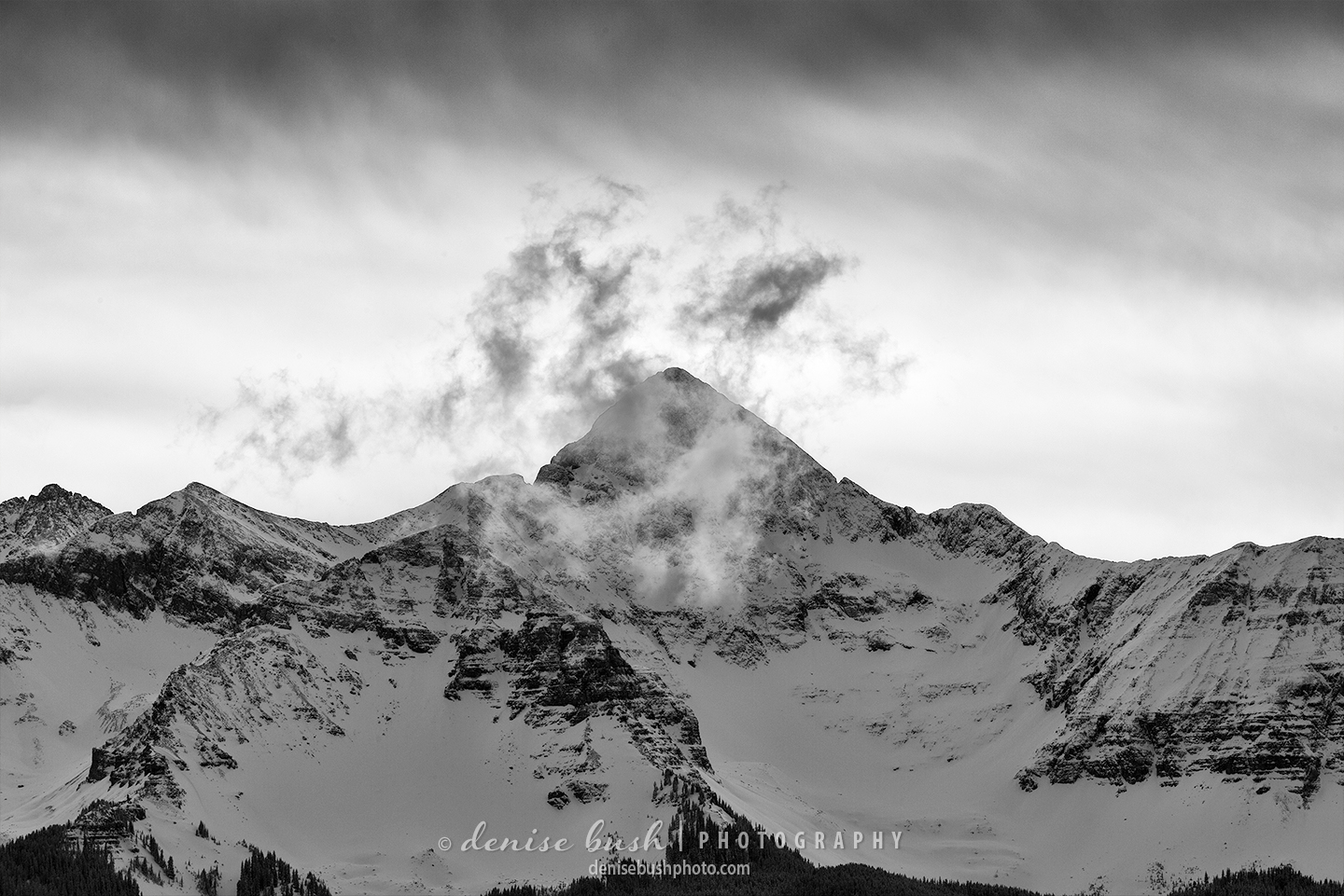 A cloud moves past Wilson Peak, near Telluride Colorado, creating a moody black and white image.